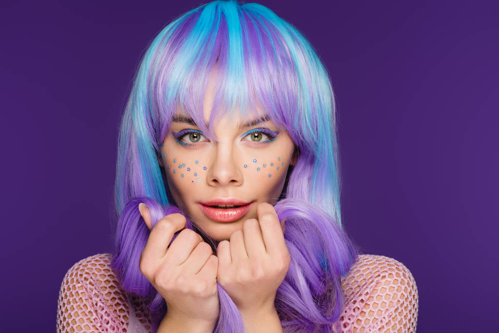 schöne stilvolle Mädchen posiert in violette Perücke mit Sternen im Gesicht, isoliert auf lila - Foto, Bild