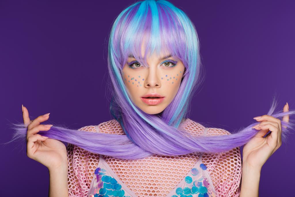 красивая молодая женщина позирует в фиолетовом парике со звездами на лице, изолированная на фиолетовый
 - Фото, изображение