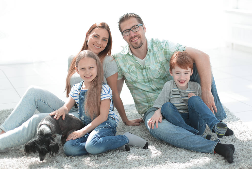 famiglia felice seduta sul tappeto in un nuovo appartamento
 - Foto, immagini