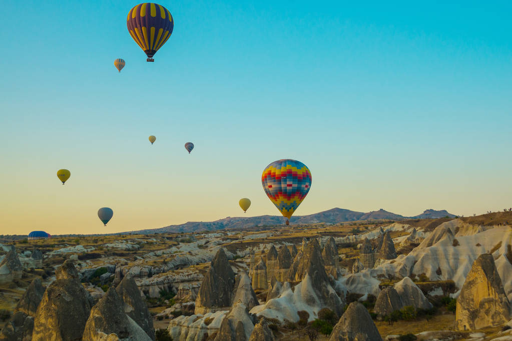 Cappadocië, Goreme, Anatolië, Turkije: Kleurrijke hete lucht ballonnen vliegen over rots landschap, Cappadocië is bekend over de hele wereld met hete lucht ballonnen en is een prachtige plek. Populaire en favoriete entertainment voor toeristen. - Foto, afbeelding