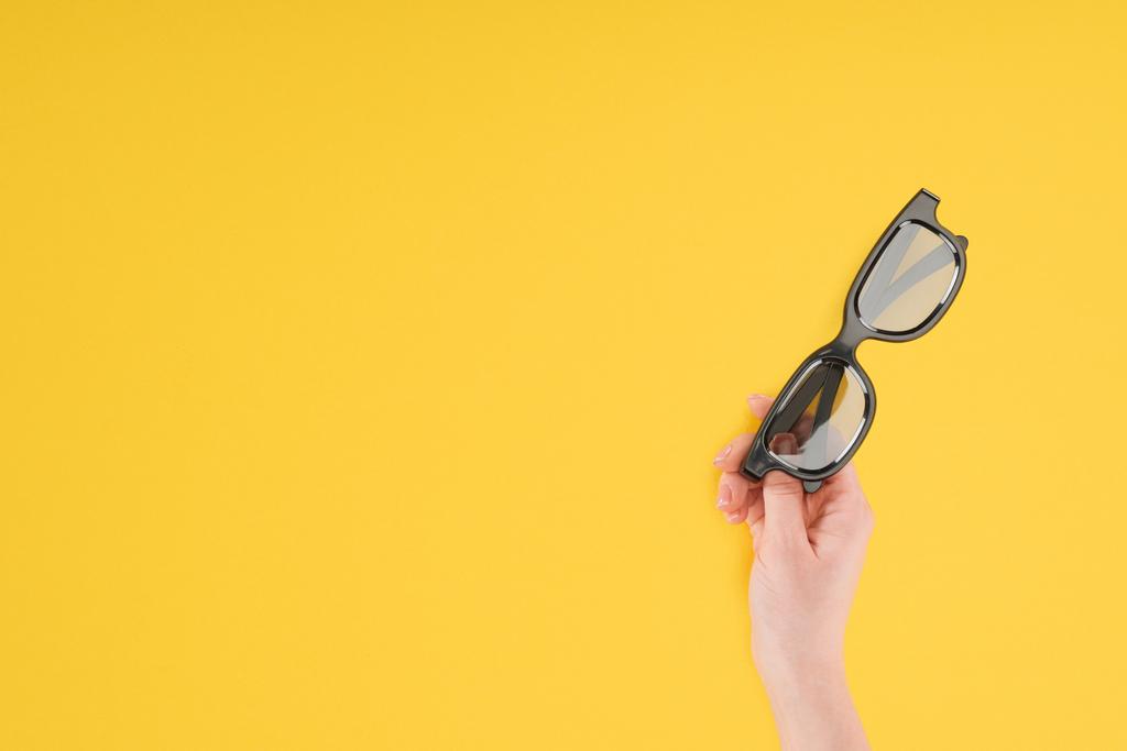 bijgesneden beeld van vrouwelijke hand hebt stereoscopische 3d bril geïsoleerd op geel - Foto, afbeelding