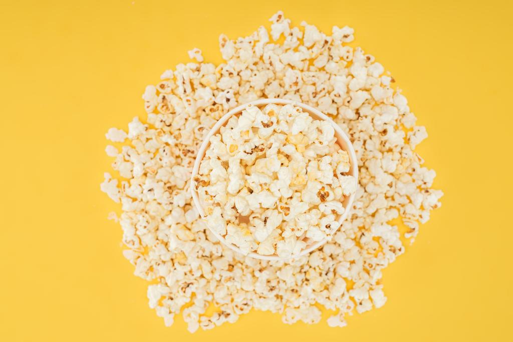 top view of carton bucket and scattered popcorn isolated on yellow - Photo, Image