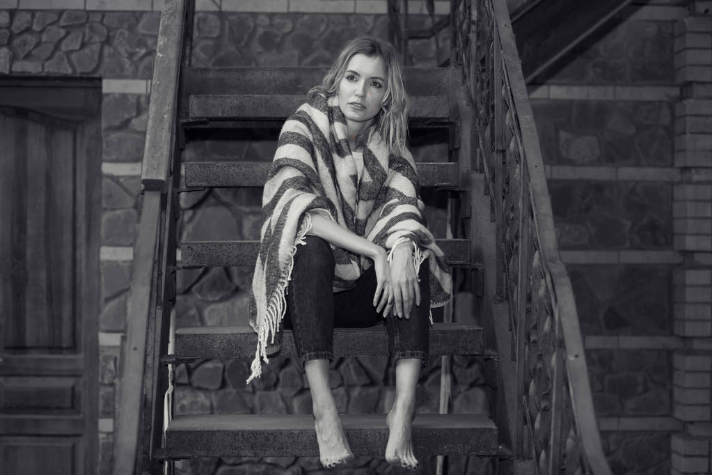 Foto en blanco y negro, retrato de una joven sentada en las escaleras de su casa
. - Foto, Imagen