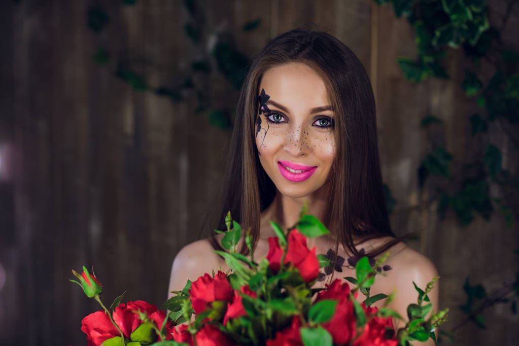 junges hübsches Mädchen, stehend und mit einer Schachtel mit roten Rosen. Mode-Stil Studio Portrait Mädchen in schwarzen eleganten Kleid stehend - Foto, Bild