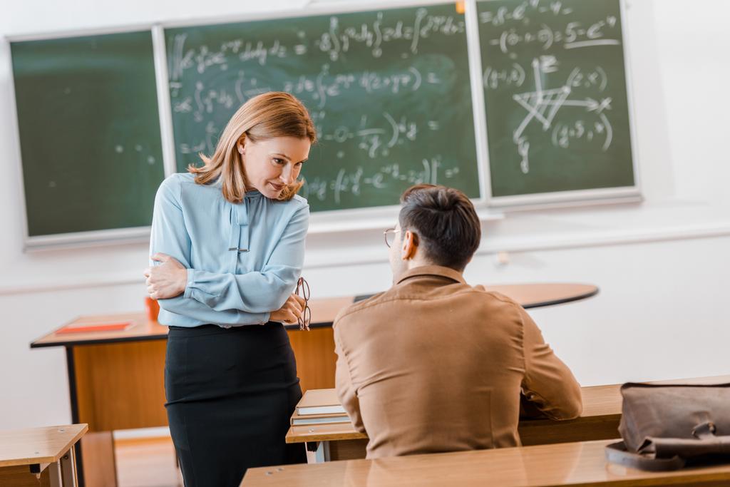 Professora e estudante do sexo masculino durante exame em sala de aula
 - Foto, Imagem