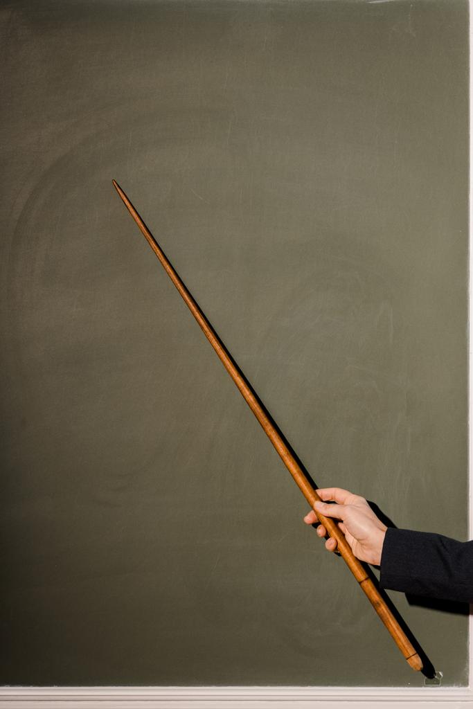Ausgeschnittene Ansicht einer Lehrerin mit Holzzeiger auf Kreidetafel-Hintergrund - Foto, Bild