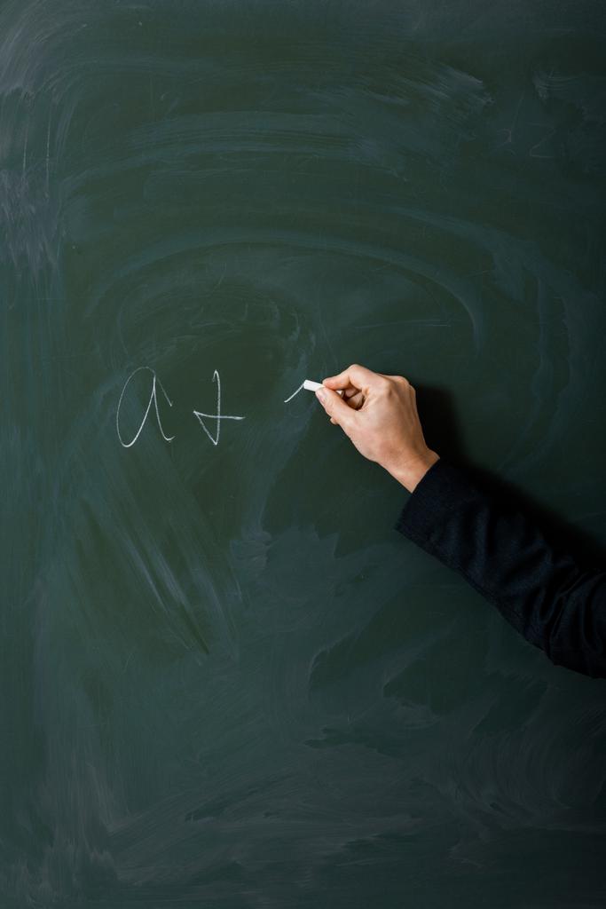 緑の黒板に方程式を書く女教師の部分的なビュー ロイヤリティフリー写真 画像素材
