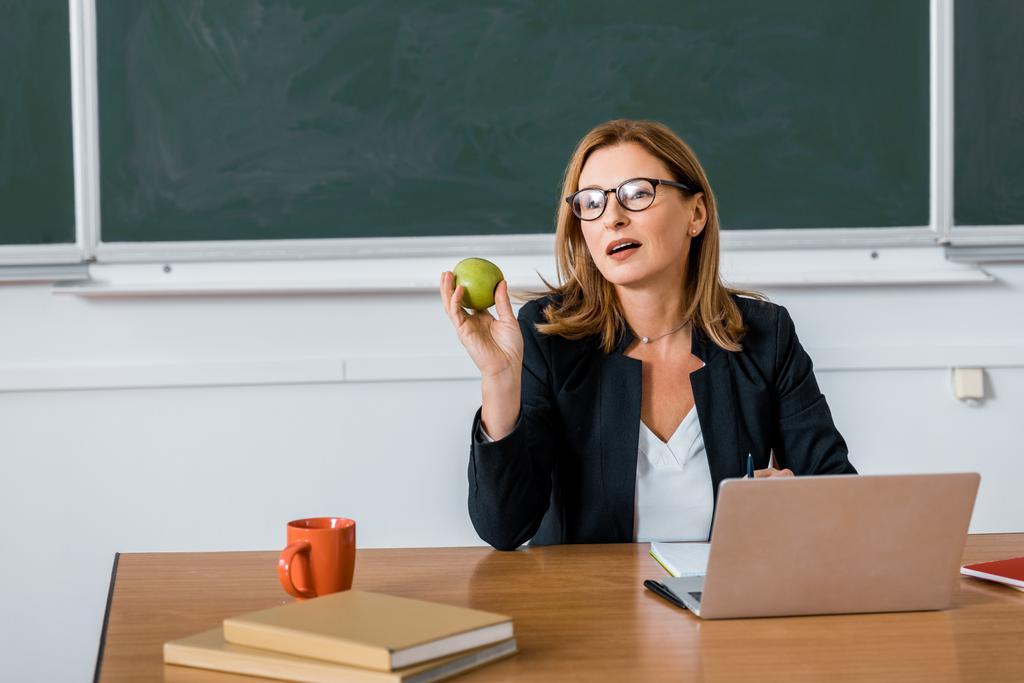 učitelek sedí u počítače, recepce a apple v učebně - Fotografie, Obrázek