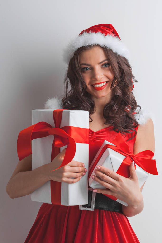 Gyönyörű fiatal nő télapó ruha ünneplő karácsony gazdaság ajándék dobozok - Fotó, kép