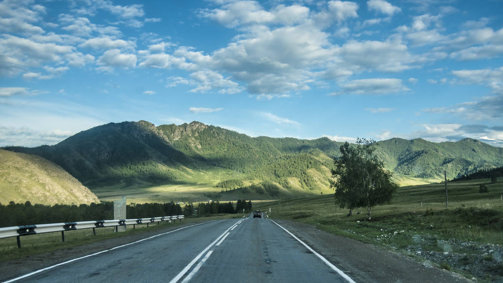 Belles vues et paysage de la nature Altaï. Perspective de la route et de l'autoroute dans l'Altaï, sur fond de montagnes majestueuses couvertes de forêt et de ciel avec des nuages
. - Photo, image