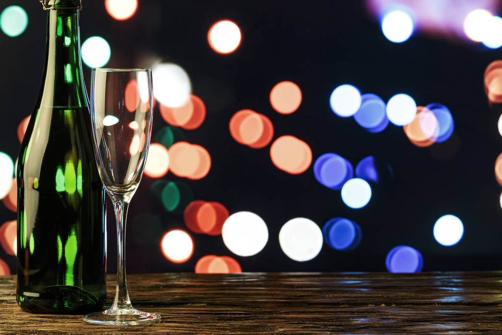 egy pohár és a New Year's boke a háttérben egy üveg pezsgő - Fotó, kép