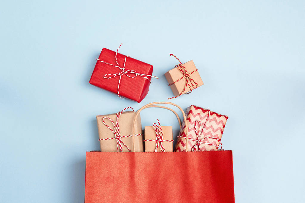 Червона торгова сумка з подарунками на синьому фоні. Концепція шопінгу та знижок на свята
. - Фото, зображення