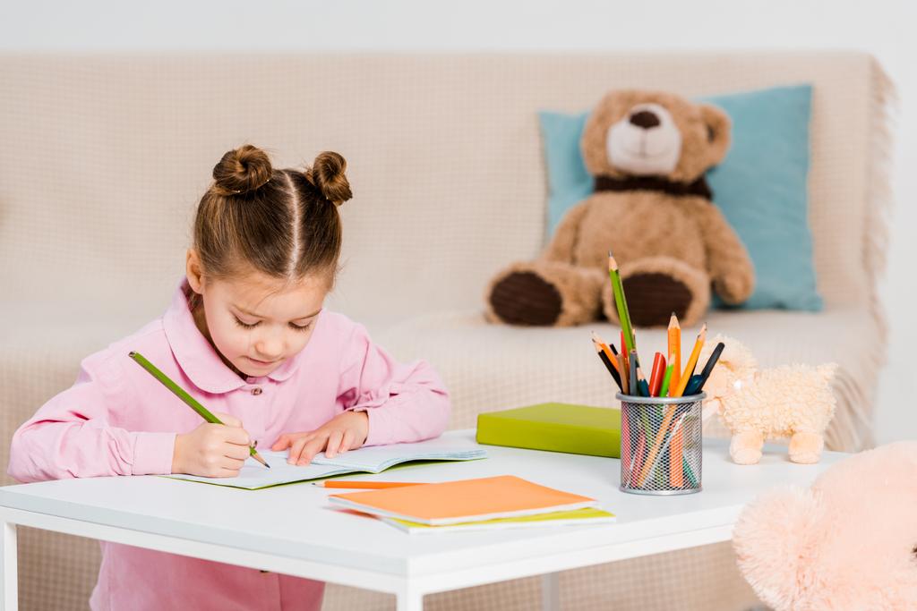 entzückend fokussiertes Kind schreibt mit Bleistift und lernt zu Hause - Foto, Bild
