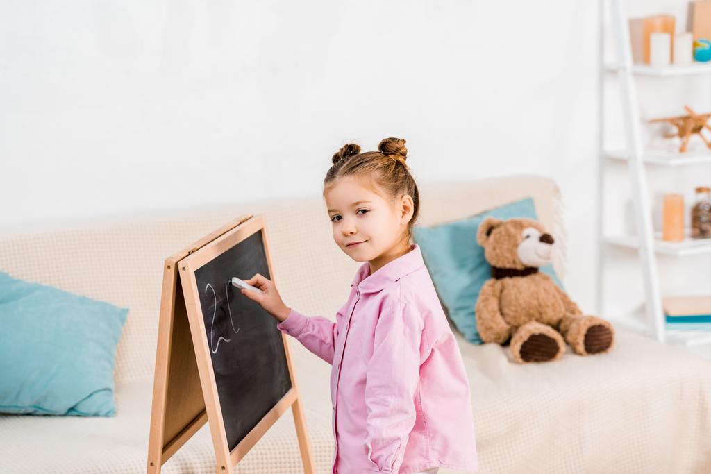 adorable dessin d'enfant sur tableau noir et souriant à la caméra
 - Photo, image