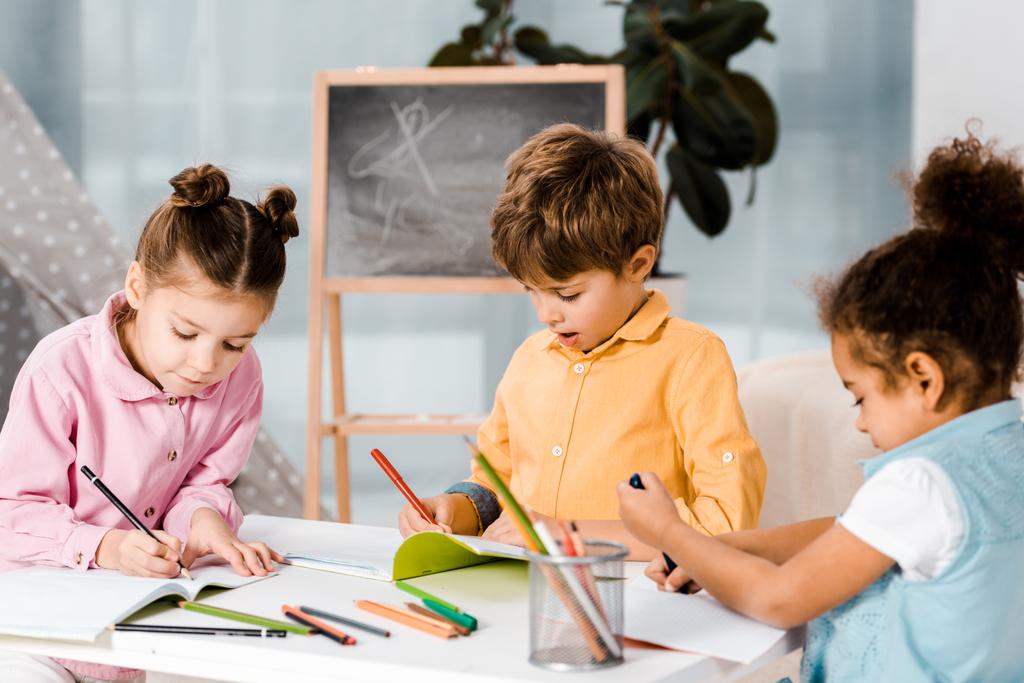 adorable little multiethnic kids drawing and studying together   - Photo, Image