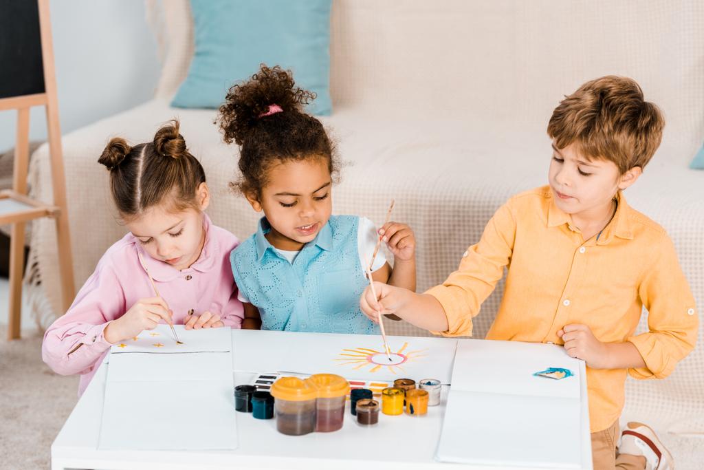 красиві багатонаціональні діти малюють пензлями разом
 - Фото, зображення