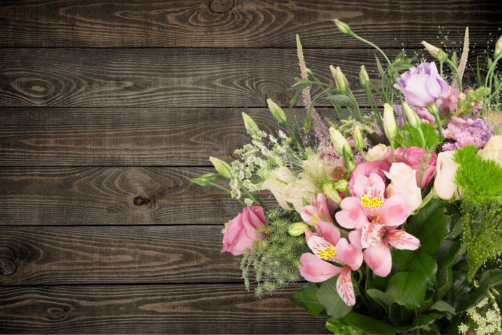 beautiful bouquet of pink flowers against wooden background - Photo, Image
