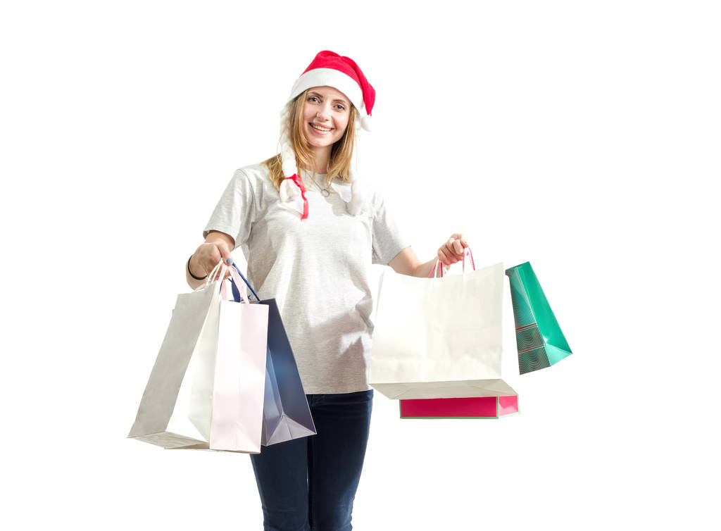 Young woman is holding a package with New Year gifts isolated on a white background. Christmas shopping. - Photo, Image