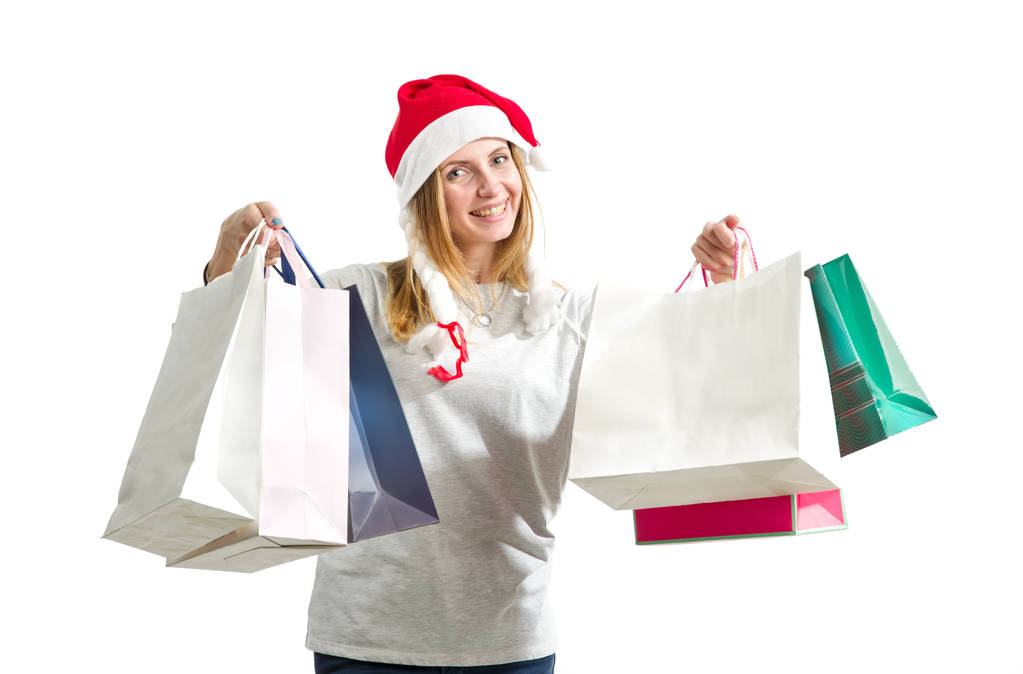 若い女性は、白い背景で隔離の新年贈り物パッケージを保持しています。クリスマスの買い物. - 写真・画像