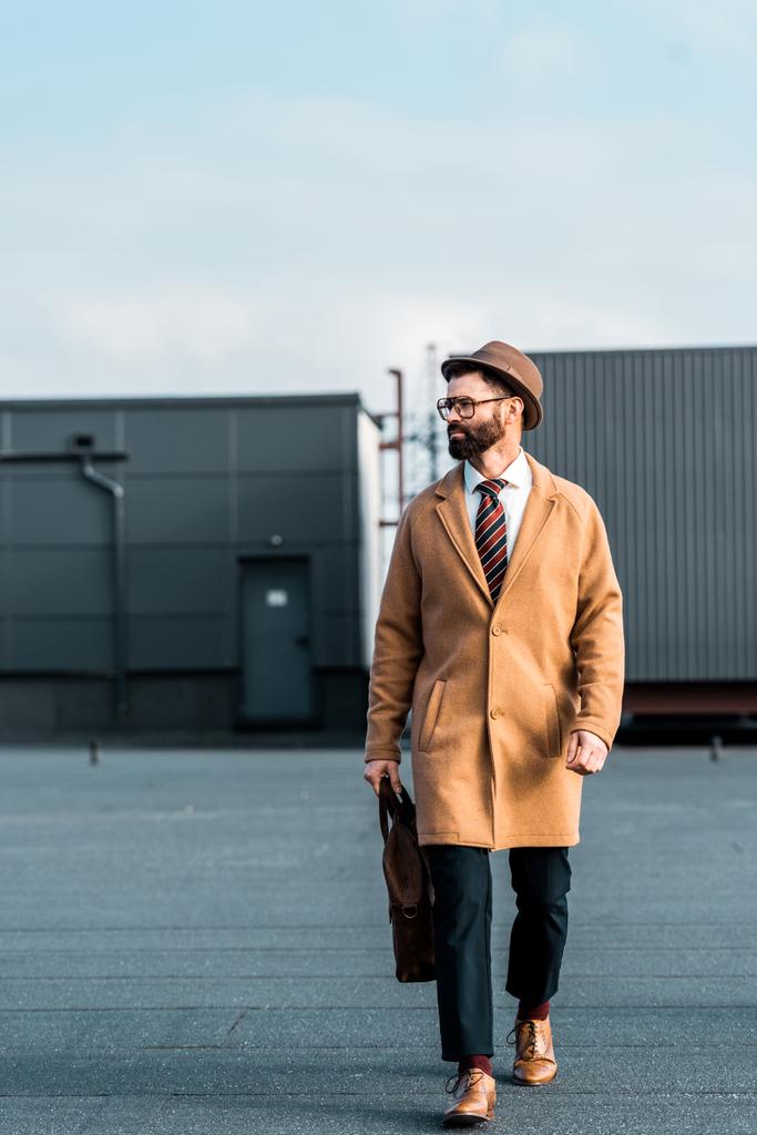 jóképű üzletember, bézs színű kabát, táska, gyaloglás-ra tető  - Fotó, kép