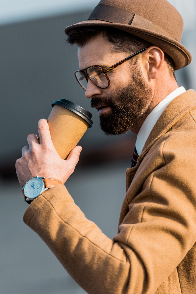 красивий бізнесмен в окулярах п'є каву з одноразової чашки
 - Фото, зображення