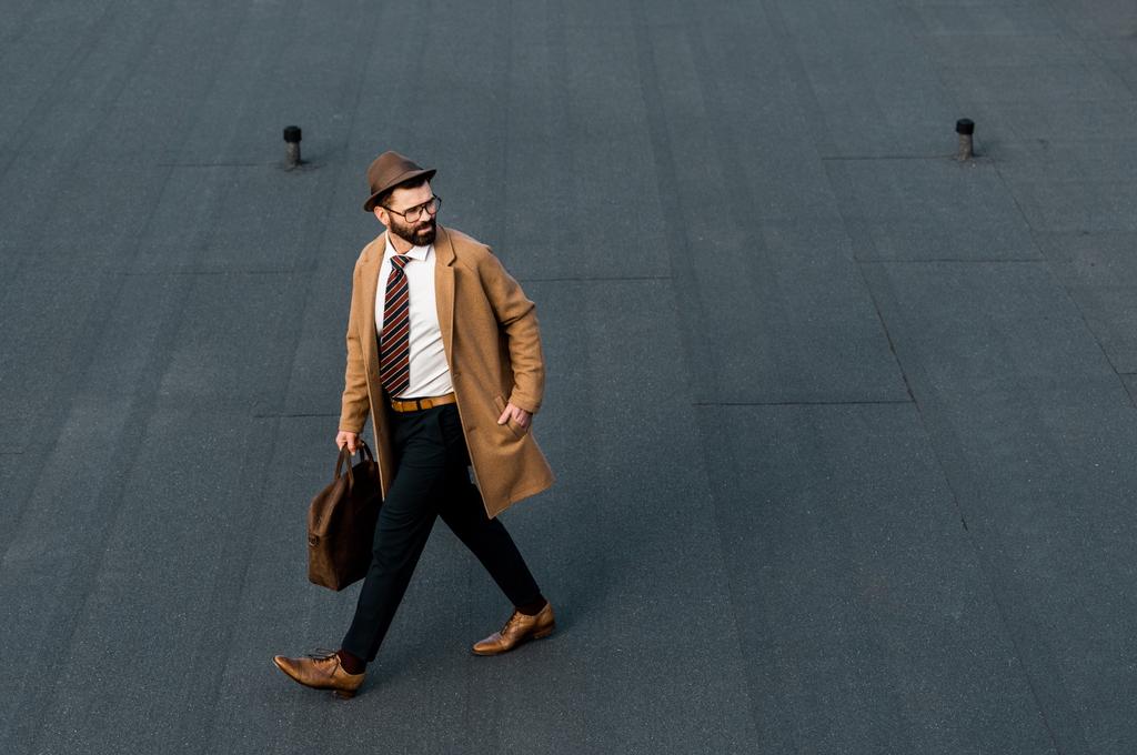 homme d'affaires barbu en manteau et chapeau marchant la main dans la poche
 - Photo, image