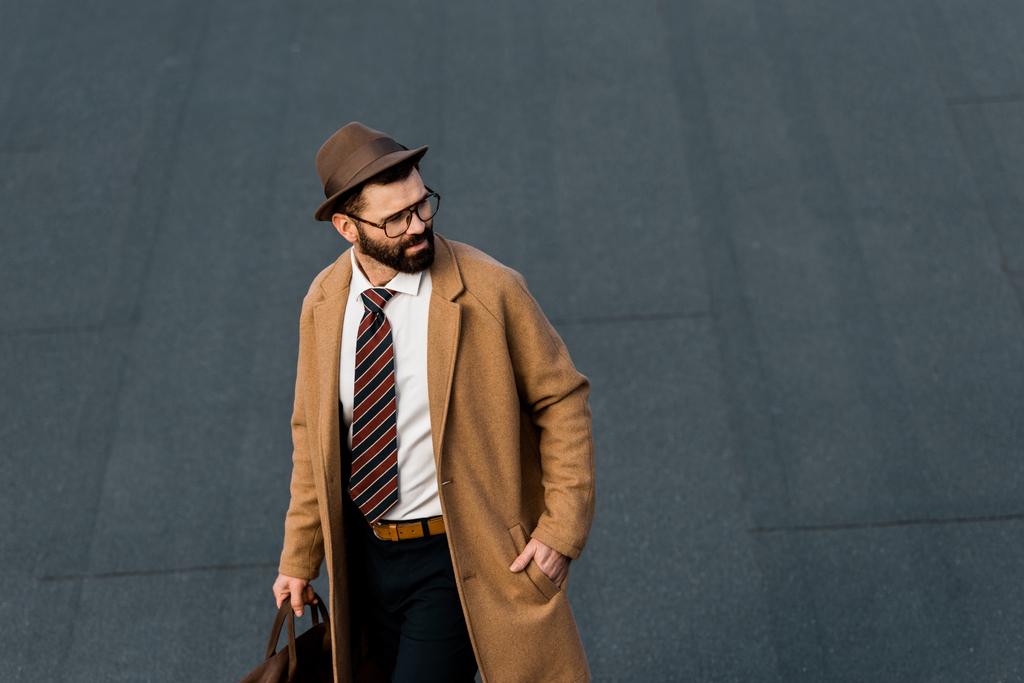Erwachsener Geschäftsmann mit Brille und Hut, die Hand in der Tasche - Foto, Bild