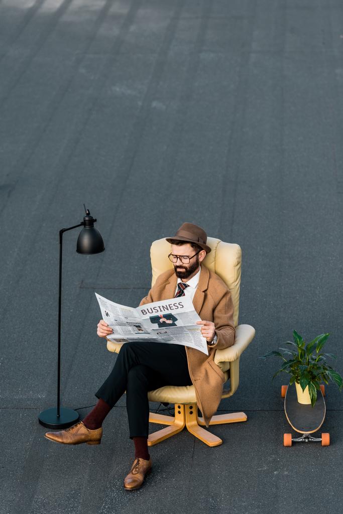 pro dospělé vousatý muž čtení obchodní noviny v křesle na střeše  - Fotografie, Obrázek