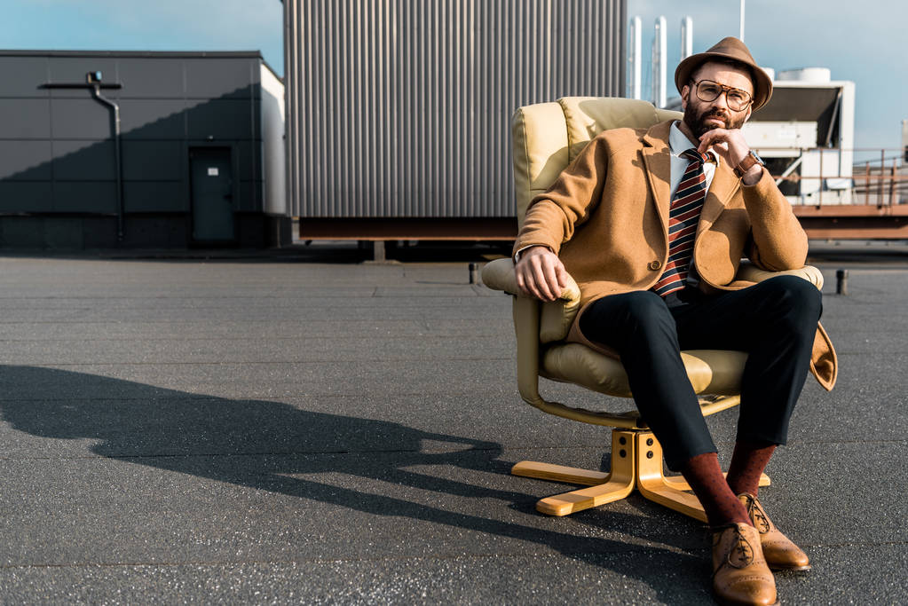 komea aikuinen liikemies istuu nojatuolissa katolla
  - Valokuva, kuva