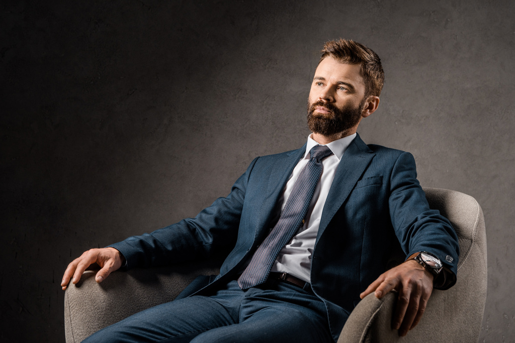 уверенный бородатый бизнесмен отдыхает в кресле
  - Фото, изображение