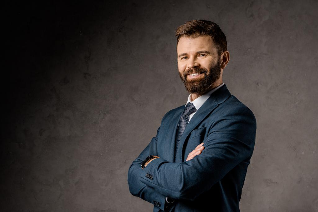 smiling bearded businessman standing with crossed arms  - Photo, Image
