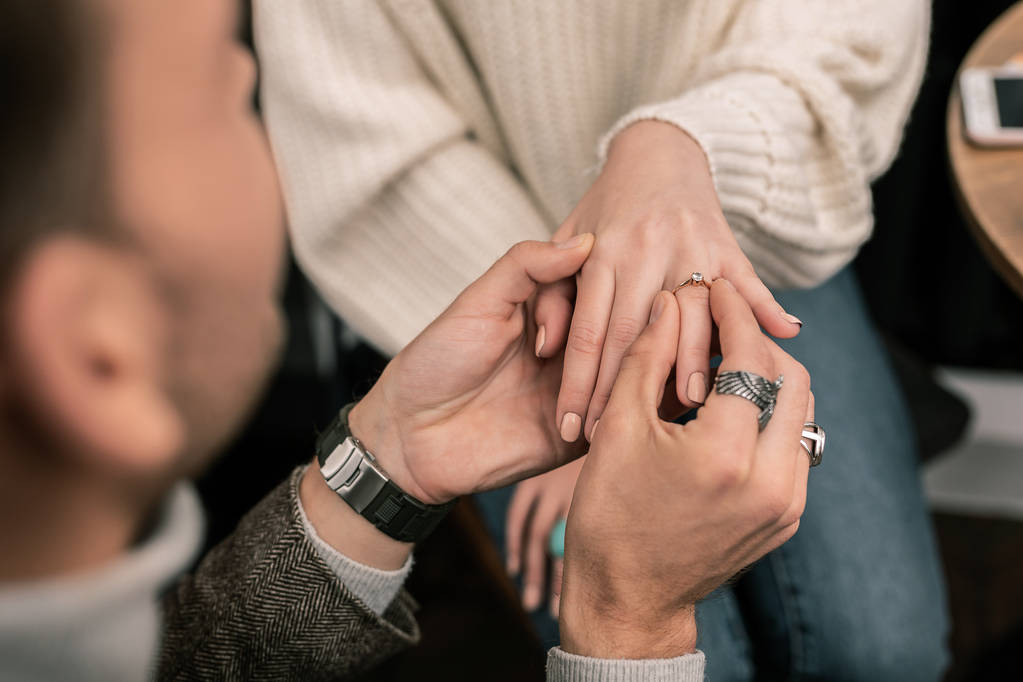 Hombre poniendo un anillo de compromiso en el dedo de las mujeres
 - Foto, imagen
