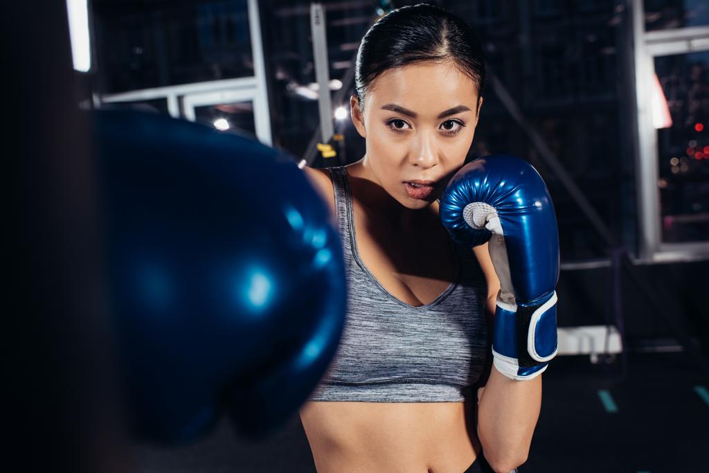 крупним планом вид азіатської дівчини в боксерських рукавичках тренування в спортзалі
 - Фото, зображення