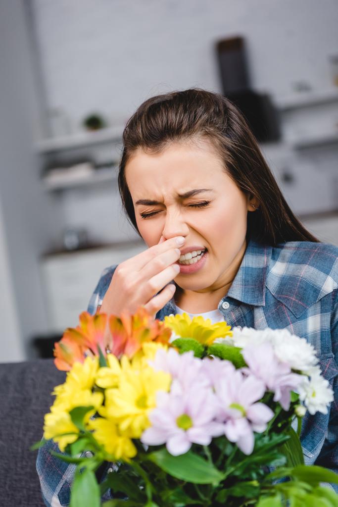 Dziewczyna z alergią, kichanie i trzymając bukiet kwiatów w domu - Zdjęcie, obraz