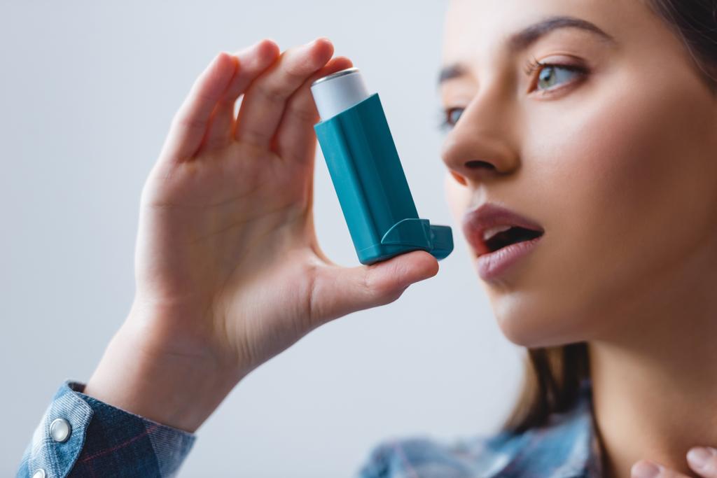 close-up view of young woman with asthma using inhaler - Photo, Image