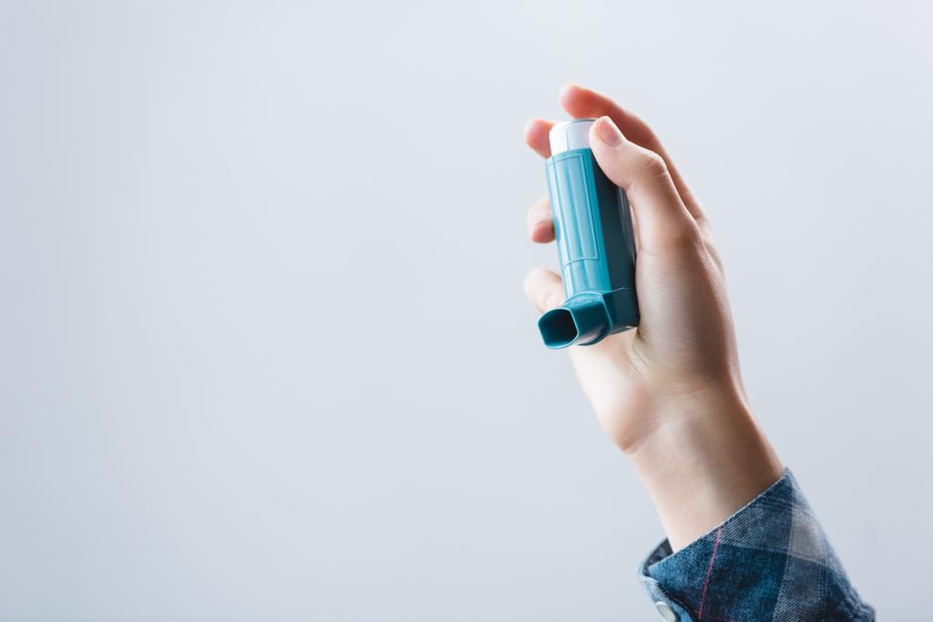 close-up partial view of young woman holding inhaler isolated on grey - Photo, Image