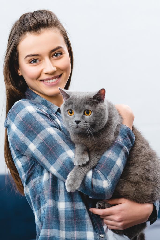 Młoda kobieta gospodarstwa Brytyjski Stenografia kot i uśmiecha się do kamery  - Zdjęcie, obraz