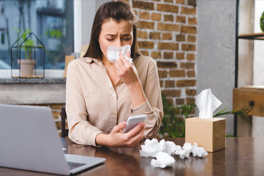 joven empresaria que usa smartphone y sufre de alergia en el lugar de trabajo
   - Foto, imagen