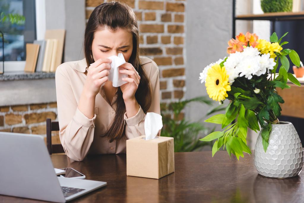 jeune femme d'affaires qui se mouche et souffre d'allergie sur le lieu de travail
 - Photo, image