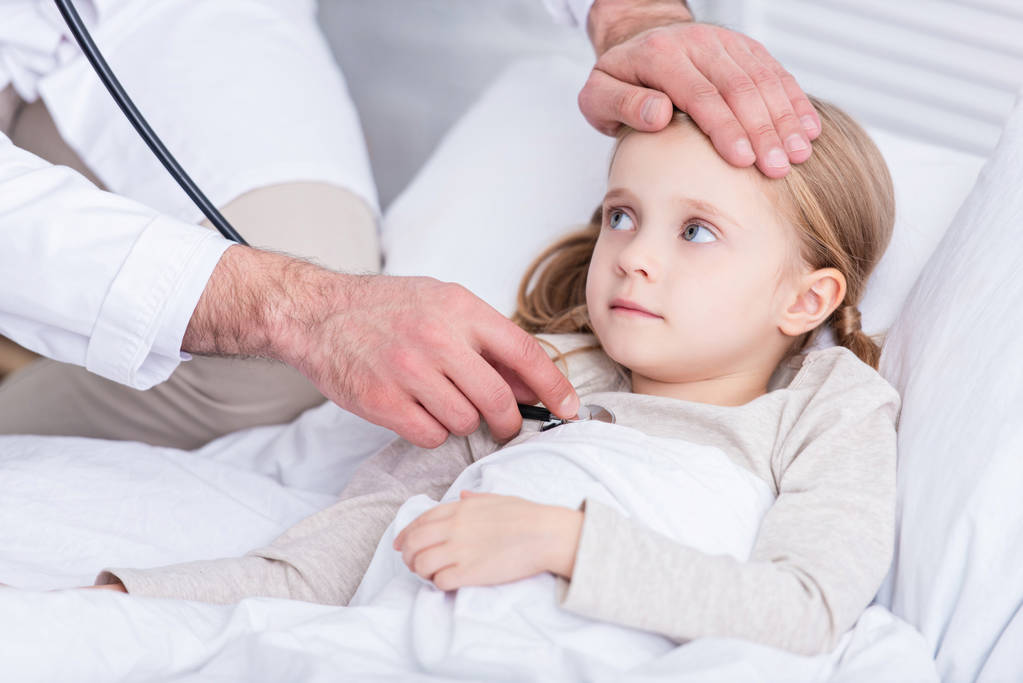 περικομμένη εικόνα της pediatrist σε λευκό παλτό εξέταση άρρωστο παιδί με στηθοσκόπιο στο σπίτι - Φωτογραφία, εικόνα