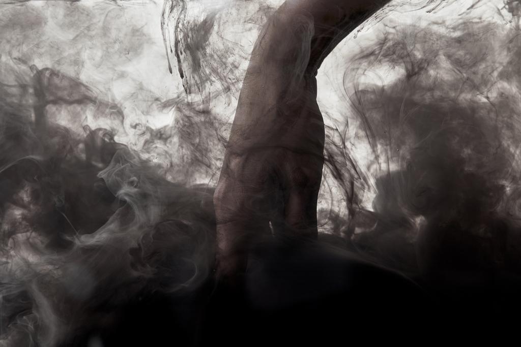 hand in water with swirls of dark paint - Photo, Image