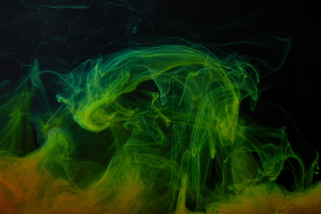 black background with abstract green and orange swirls of paint  - Photo, Image