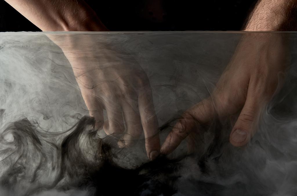 vista recortada de tierna pareja tocando los dedos en agua con pintura negra
 - Foto, Imagen