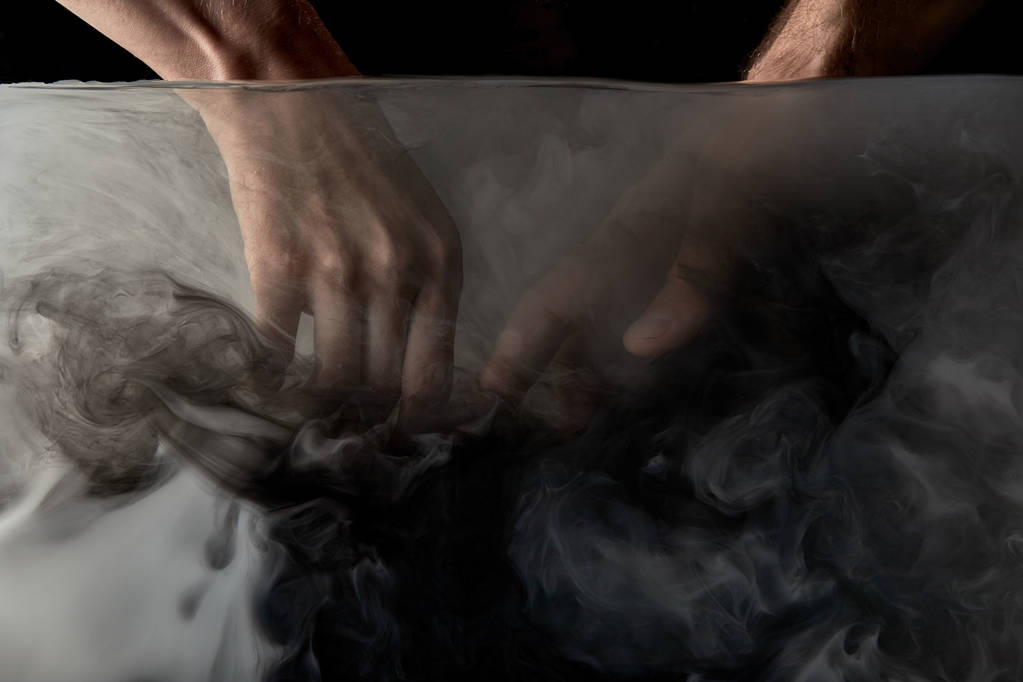 частковий вид ніжної пари, що торкається пальців у воді з чорною фарбою
 - Фото, зображення