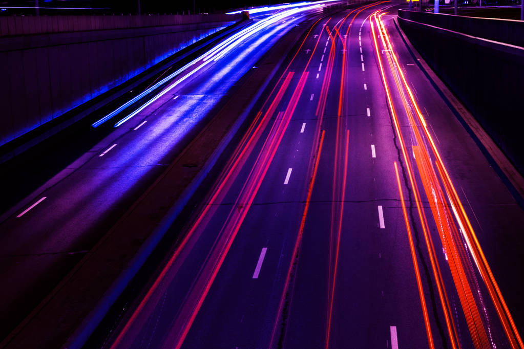 Cars light trails on a curved highway at night. Night traffic trails. Motion blur. Night city road with traffic headlight motion. Cityscape. Light up road by vehicle motion blur. - Photo, Image
