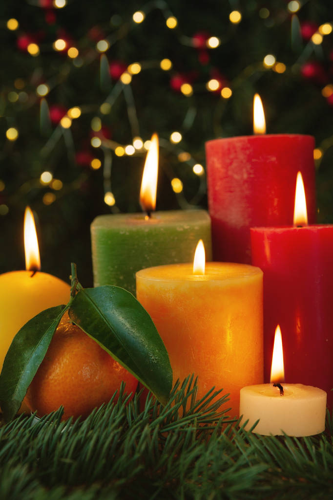 Weihnachtskomposition mit brennenden Kerzen, Mandarinen- und Tannenzweigen mit Girlanden auf Hintergrund  - Foto, Bild
