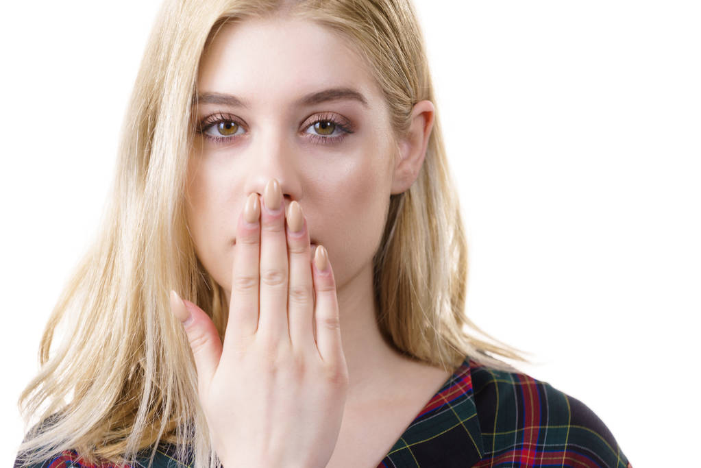 close-up van jonge blonde vrouw tonen stilte gebaar verbergen haar mond wezen handen. - Foto, afbeelding