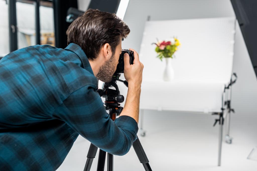 молодой человек фотографирует красивые цветы в профессиональной фотостудии
   - Фото, изображение