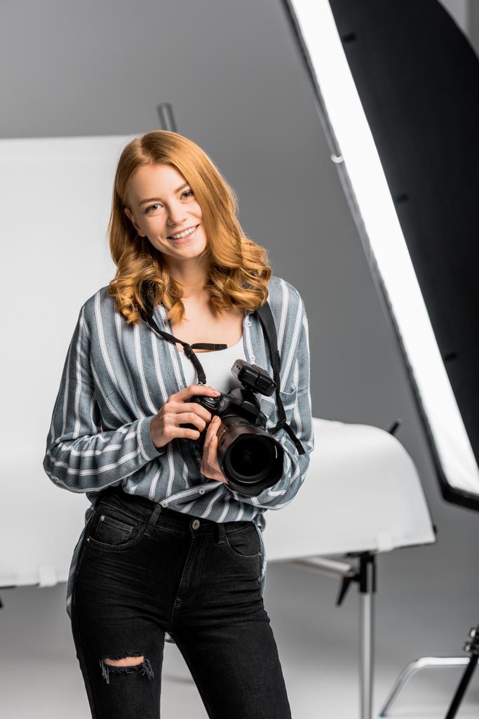 piękna młoda kobieta fotograf uśmiecha się do kamery w studio fotograficzne - Zdjęcie, obraz