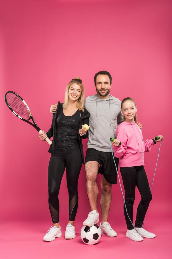 Sportliche Familie mit Sportausrüstung auf rosa - Foto, Bild